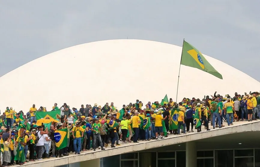 Supporters of Brazilian former President Jair Bolsonaro invade the National Congress in Brasilia on January 8, 2023. - Hundreds of supporters of Brazil's far-right ex-president Jair Bolsonaro broke through police barricades and stormed into Congress, the presidential palace and the Supreme Court Sunday, in a dramatic protest against President Luiz Inacio Lula da Silva's inauguration last week. (Photo by Sergio Lima / AFP)